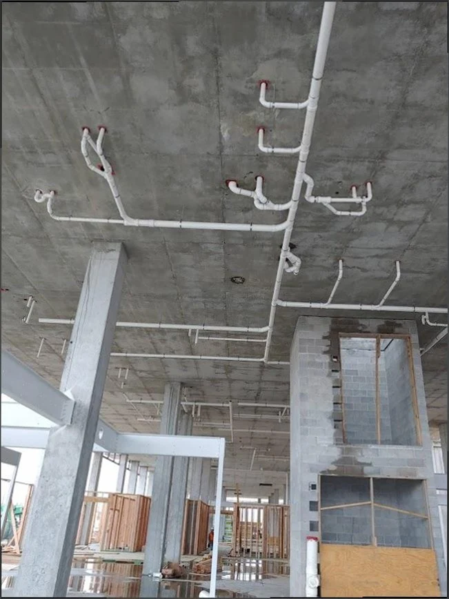 Commercial overhead PVC plumbing installation on concrete ceiling by Sandy Springs Plumbing