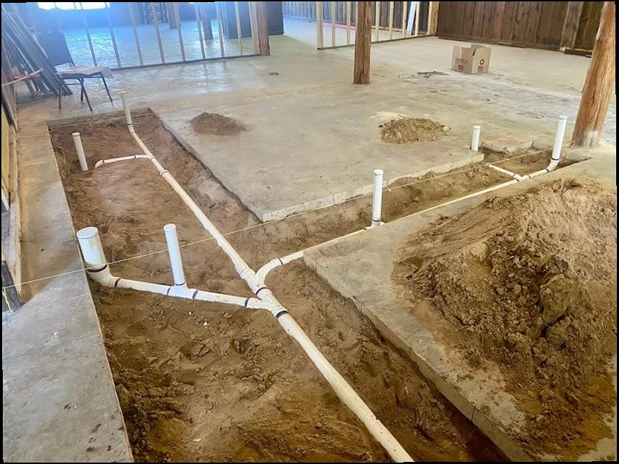 New construction under-slab plumbing rough-in with trenched PVC drain lines by Sandy Springs Plumbing